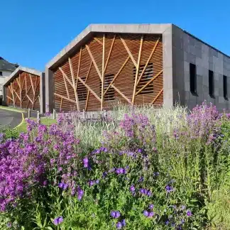 Photo de l'atelier du village de Orcines avec en premier plan des fleurs de couleur violette