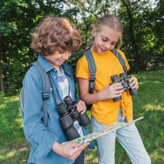 2 enfants (fille et garçon) regardant une carte d'exploration et portant des jumelles