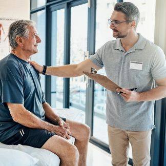 Image d’un patient assis sur une table de massage et d’un professionnel de santé